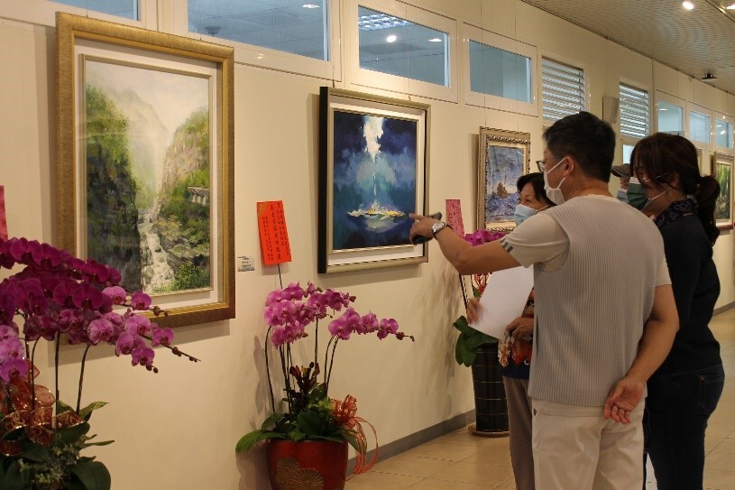 Figure 5. The artist explains the design concept and inspiration behind the exhibition artworks to visitors