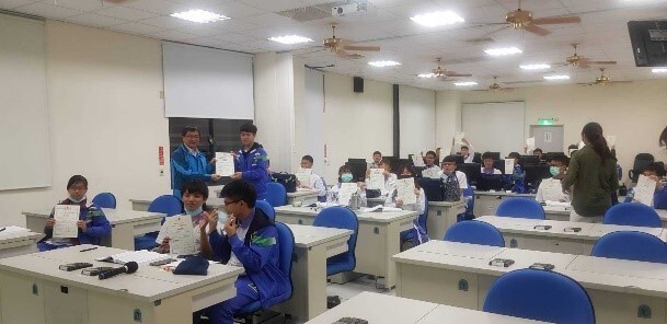 Figure 19. Wun-Jie Shih, principal of the Affiliated Industrial Vocational High School of NCUE, providing the certificate of graduation to students